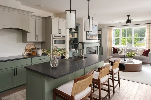 a kitchen with a dining table chairs and living room view
