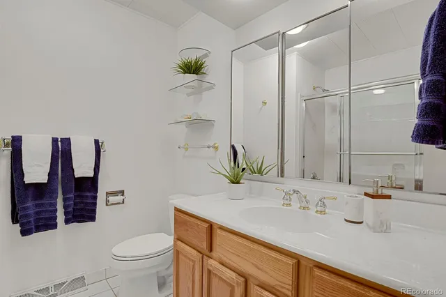 a bathroom with a granite countertop sink a toilet and shower