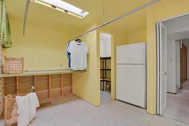 a view of a bedroom with furniture and a refrigerator