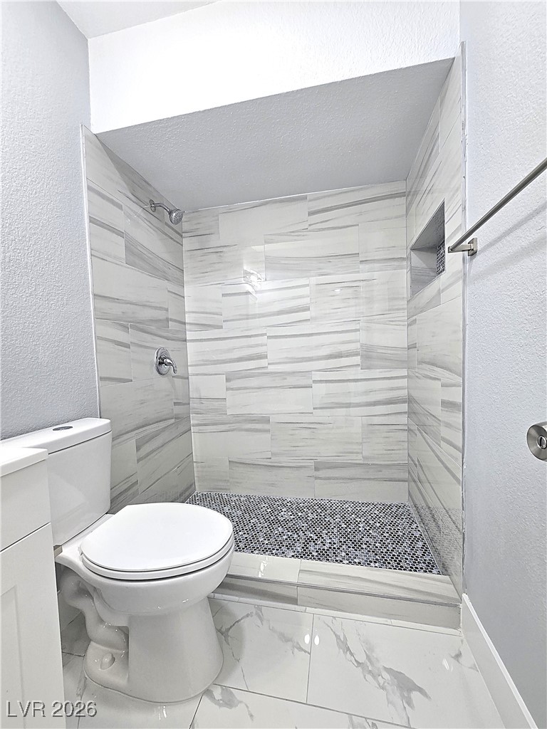 1437 Chestnut Street Henderson, NV 89011 - Photo 13 of 23 Full bathroom with a textured wall, a stall shower, marble look tile flooring, a textured ceiling, and vanity