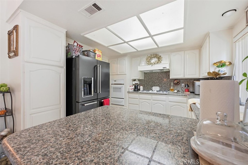 6266 Shaker Drive Riverside, CA 92506 - Photo 16 of 72 a kitchen with kitchen island granite countertop a sink cabinets and stainless steel appliances