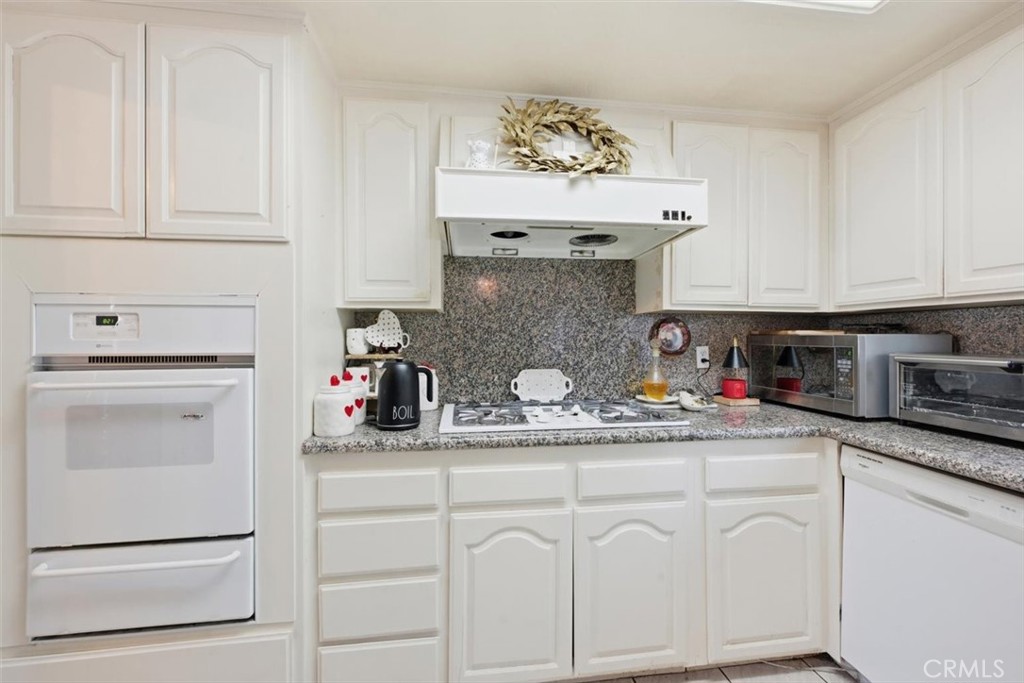 6266 Shaker Drive Riverside, CA 92506 - Photo 18 of 72 a kitchen with white cabinets and a stove