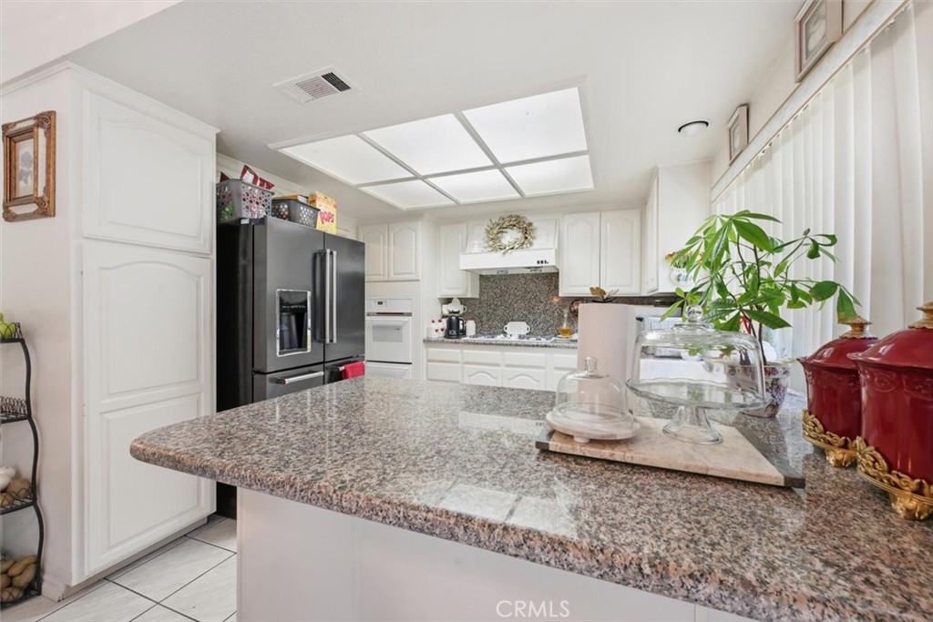 6266 Shaker Drive Riverside, CA 92506 - Photo 19 of 72 a kitchen with kitchen island a counter top space a sink appliances and cabinets