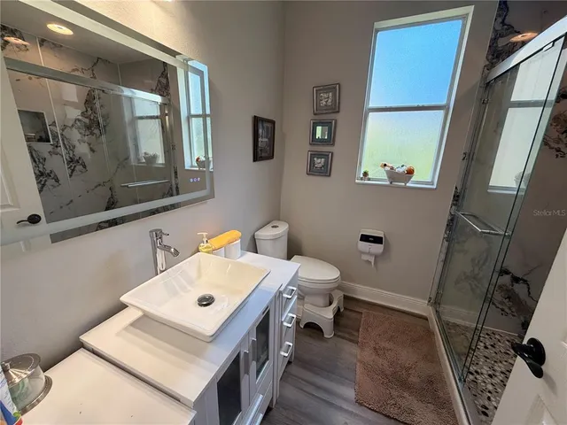 a bathroom with a sink a toilet and a mirror