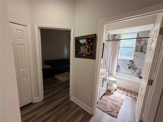 a view of a hallway with wooden floor and staircase