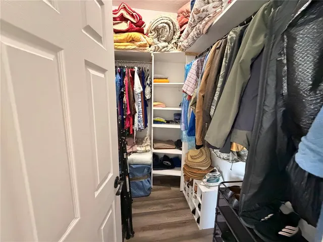 a view of walk in closet with clothes and shoes