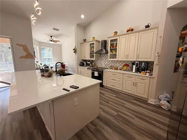 a kitchen with white cabinets and sink