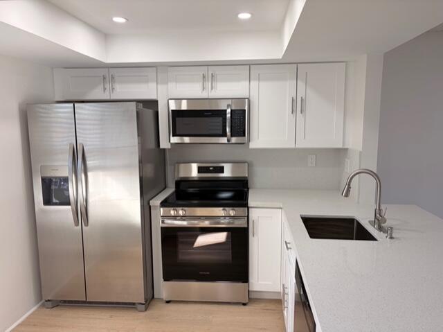 9374 Southwest 3rd Street, Unit 714 Boca Raton, FL 33428 - Photo 3 of 21 a kitchen with stainless steel appliances a refrigerator a sink a stove top oven and white cabinets