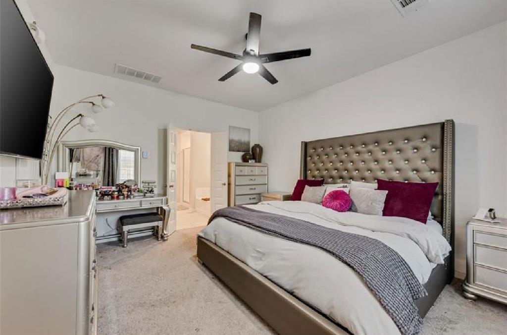 3911 Rochelle Lane Crandall, TX 75114 - Photo 12 of 16 a bedroom with a large bed and a chandelier