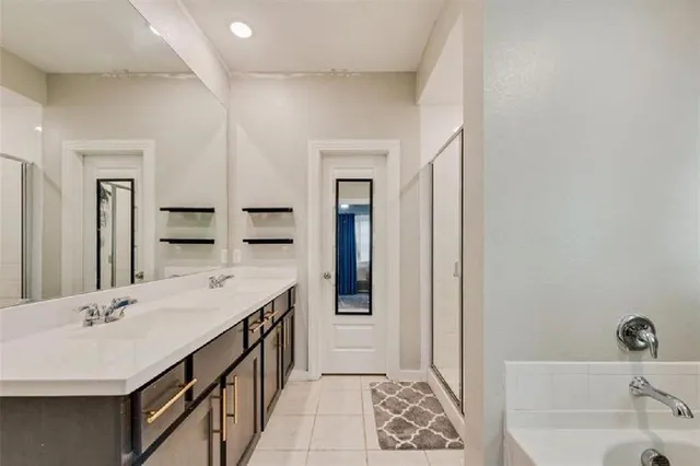 a bathroom with a tub sink and mirror