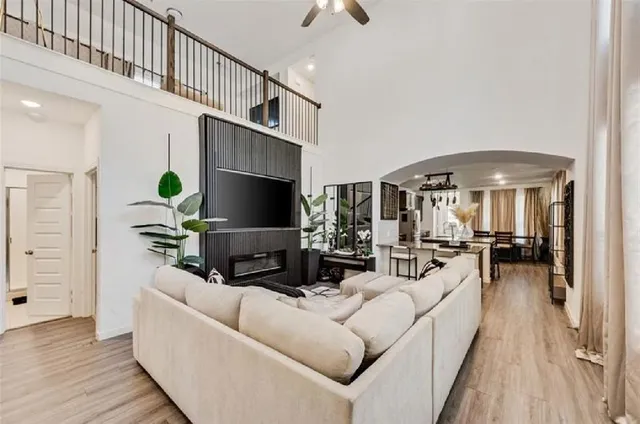 a living room with furniture a chandelier and a flat screen tv