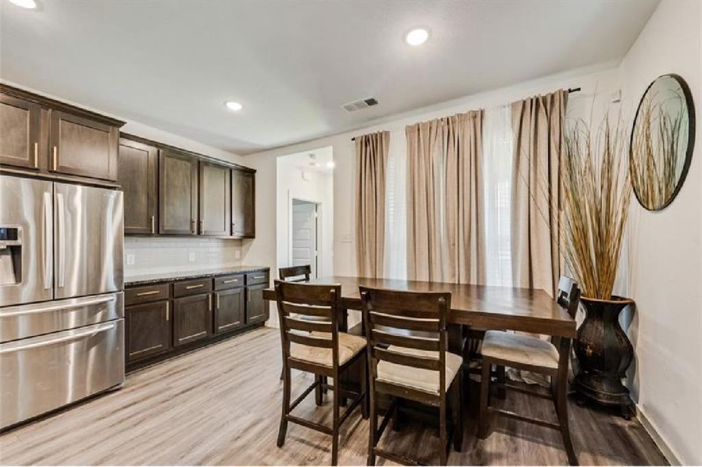 3911 Rochelle Lane Crandall, TX 75114 - Photo 10 of 16 a kitchen with a table chairs refrigerator and cabinets