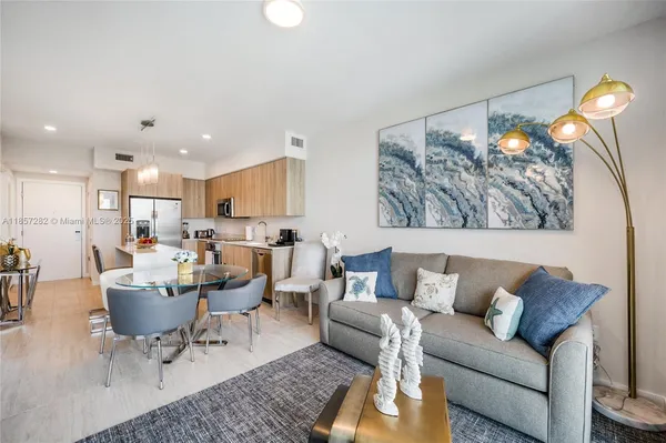 a living room with furniture and a dining table with wooden floor