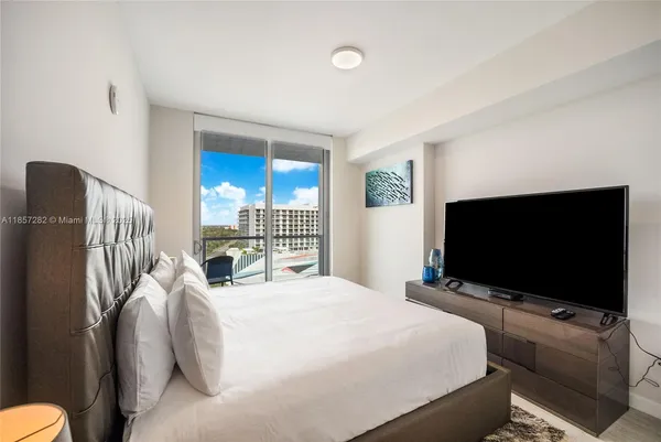 a bedroom with a bed and a flat screen tv