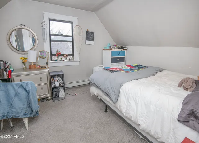 a bedroom with a bed a mirror and a window