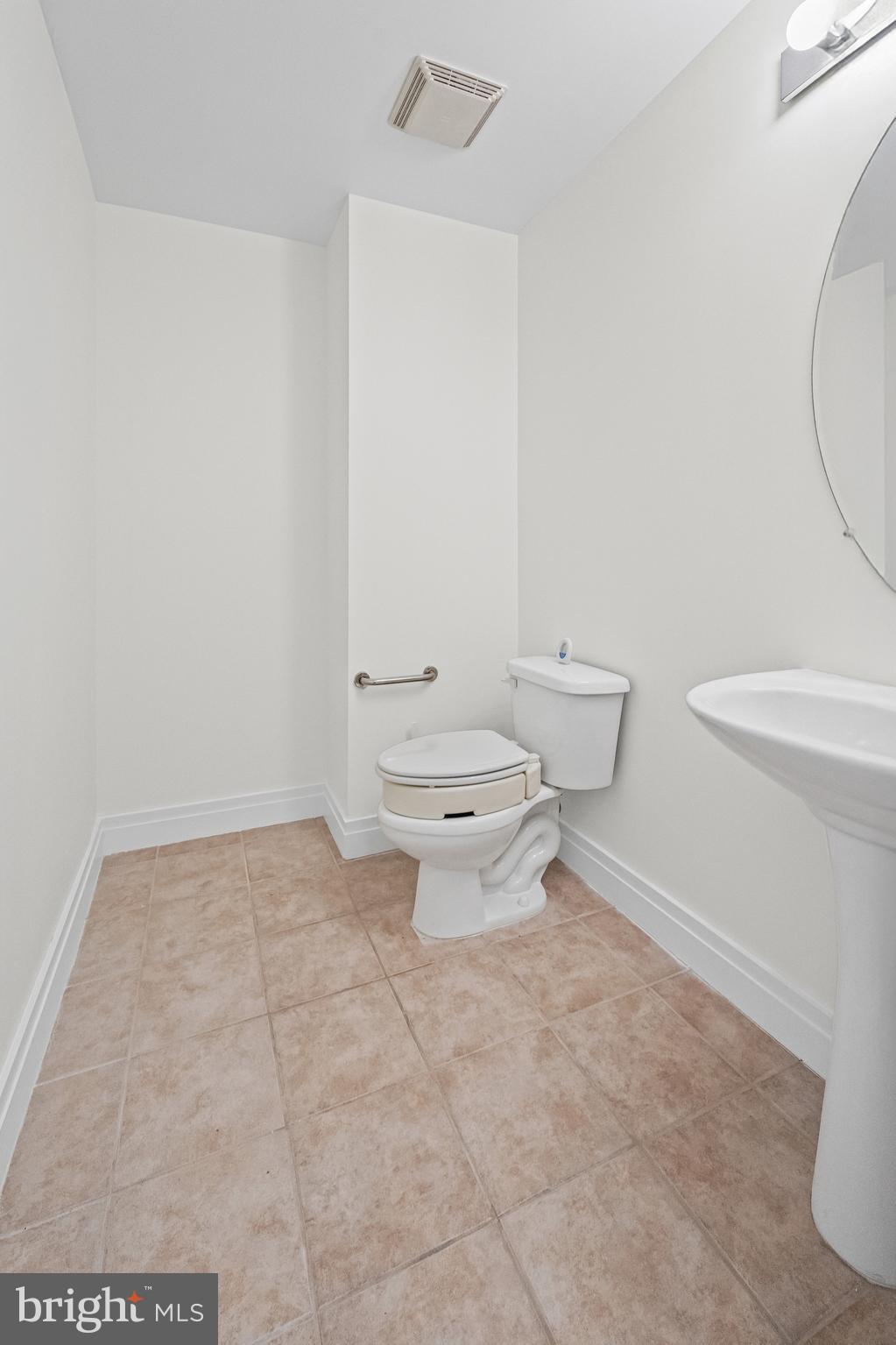 414 Water Street, Unit 2903 Baltimore, MD 21202 - Photo 31 of 46 a white toilet sitting next to a white sink and vanity