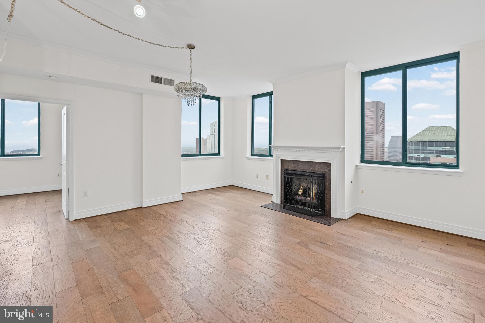 414 Water Street, Unit 2903 Baltimore, MD 21202 - Photo 9 of 46 a view of an empty room with wooden floor fireplace and a window