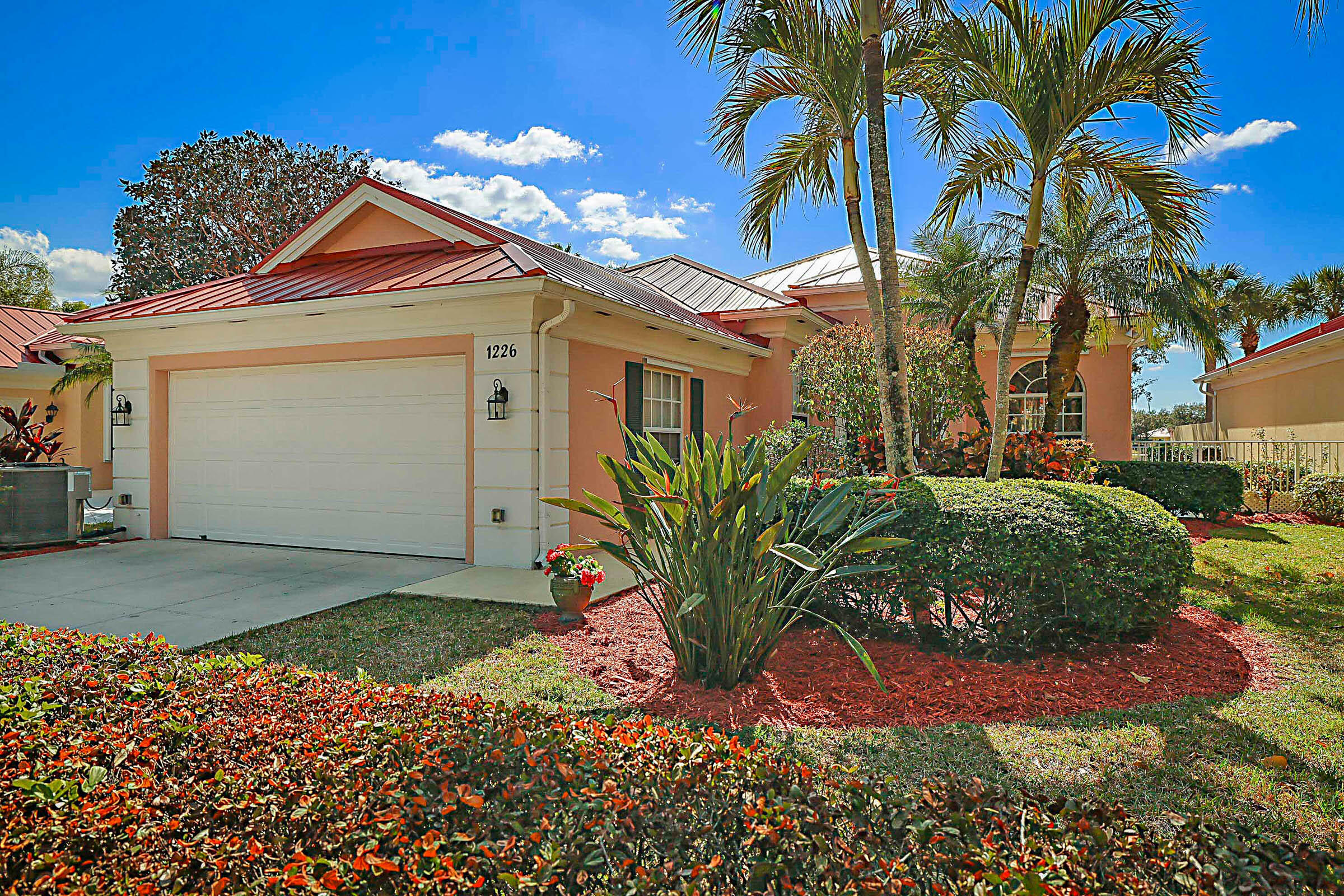 1226 Southwest Eagleglen Place Stuart, FL 34997 - Photo 1 of 45 a front view of a house with a yard and garage
