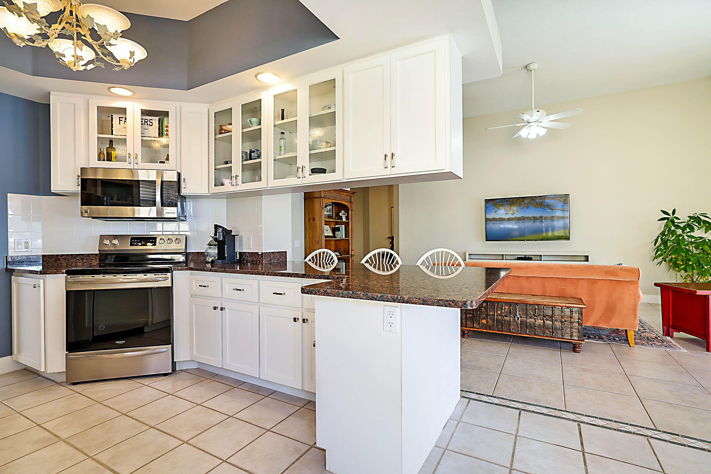 1226 Southwest Eagleglen Place Stuart, FL 34997 - Photo 14 of 45 a kitchen with stainless steel appliances granite countertop a stove a sink dishwasher and a microwave