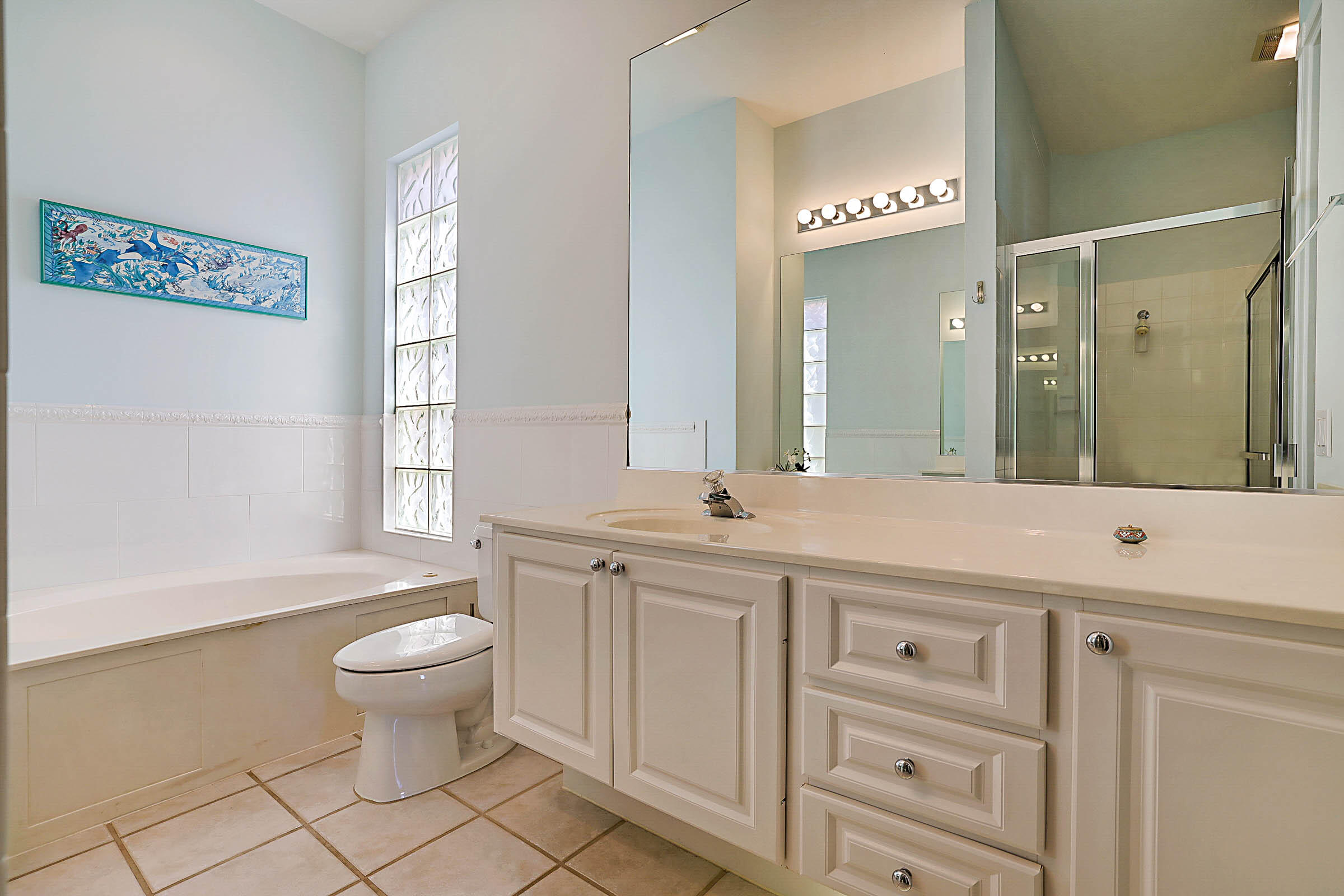 1226 Southwest Eagleglen Place Stuart, FL 34997 - Photo 25 of 45 a spacious bathroom with a granite countertop sink toilet a mirror and a bathtub