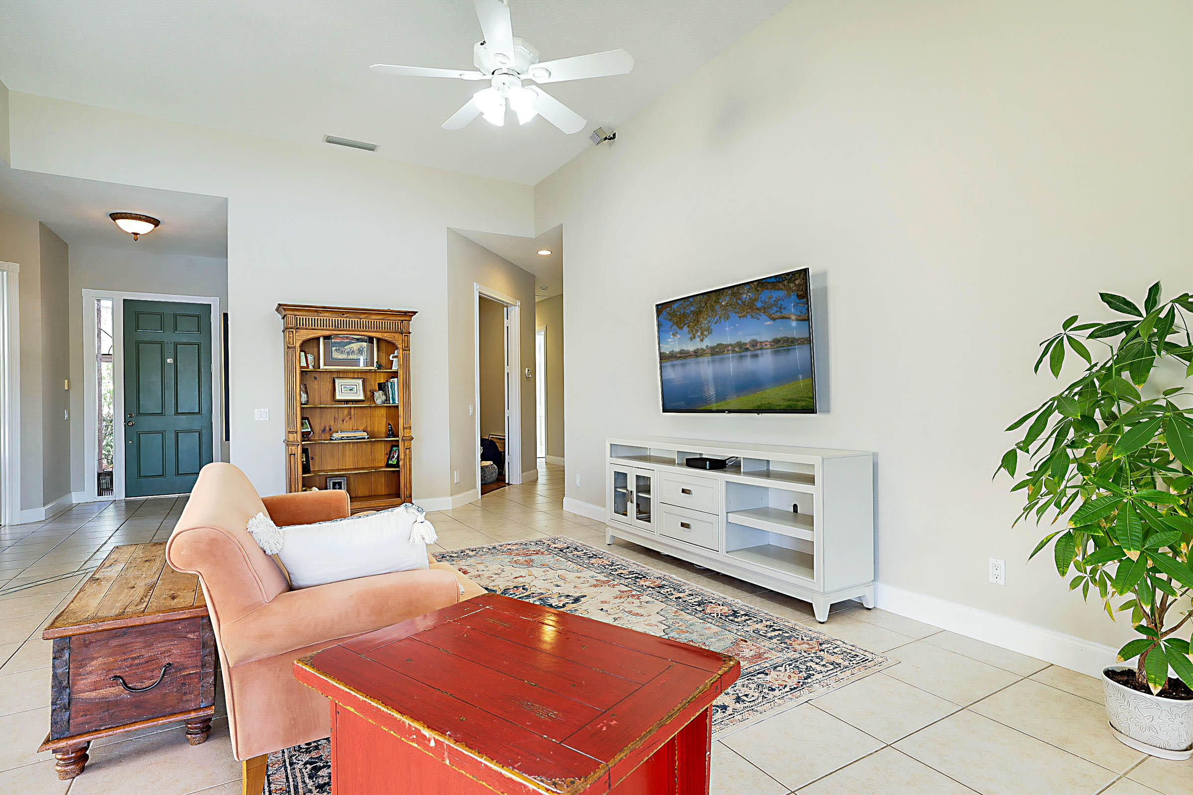 1226 Southwest Eagleglen Place Stuart, FL 34997 - Photo 4 of 45 a living room with furniture a flat screen tv and a potted plant
