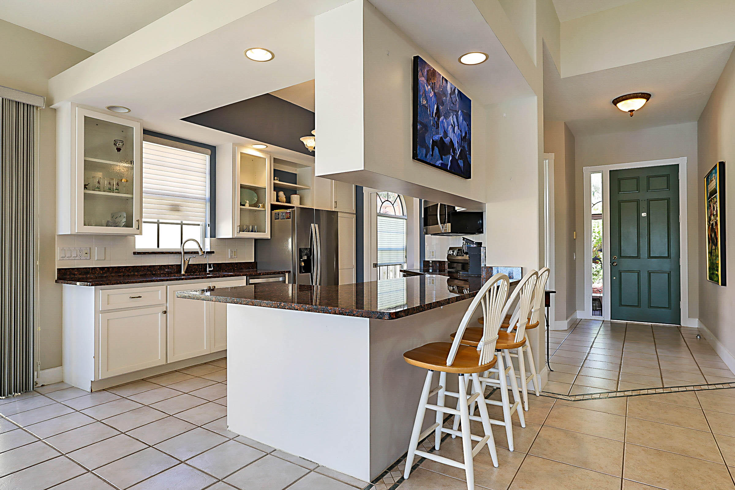 1226 Southwest Eagleglen Place Stuart, FL 34997 - Photo 8 of 45 a kitchen with stainless steel appliances kitchen island granite countertop a sink and cabinets