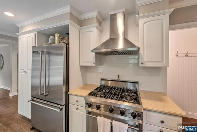 a kitchen with stainless steel appliances granite countertop a stove and a refrigerator