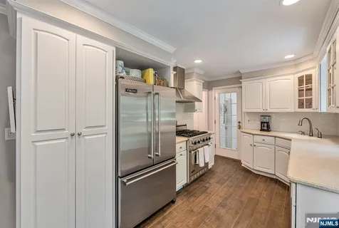 a kitchen with stainless steel appliances a refrigerator sink and cabinets