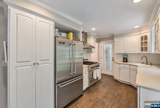 a kitchen with stainless steel appliances a refrigerator sink and cabinets