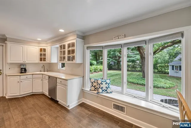 a open kitchen with a large window and white cabinets