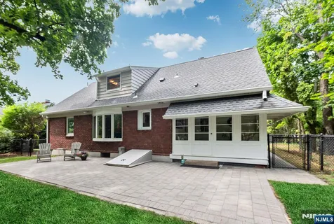 a view of a house with a backyard and sitting area