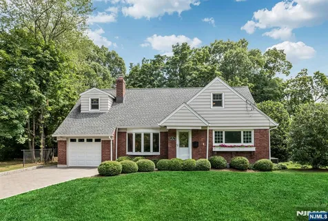 a view of a house with a yard and potted plants