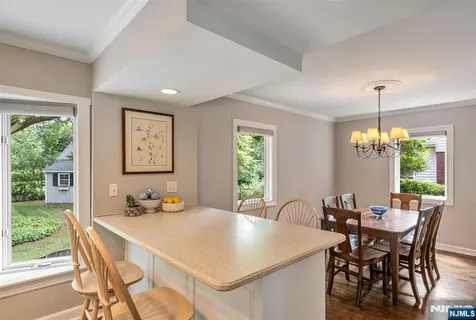 a view of a dining room and livingroom with furniture window and wooden floor