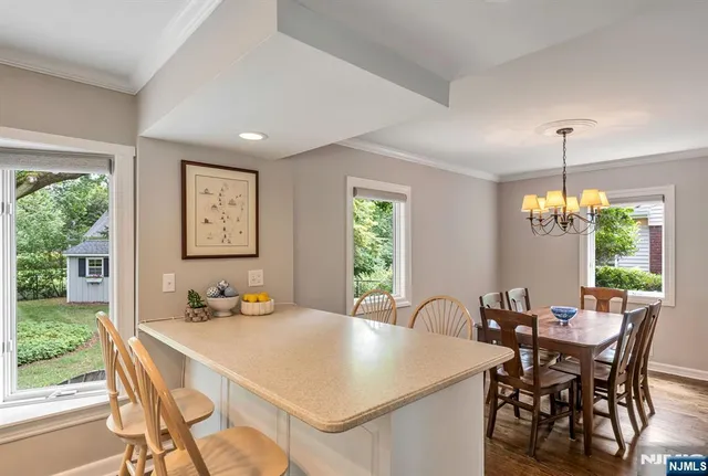 a view of a dining room and livingroom with furniture window and wooden floor