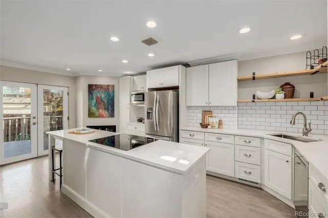 a kitchen that has a sink a stove and a refrigerator