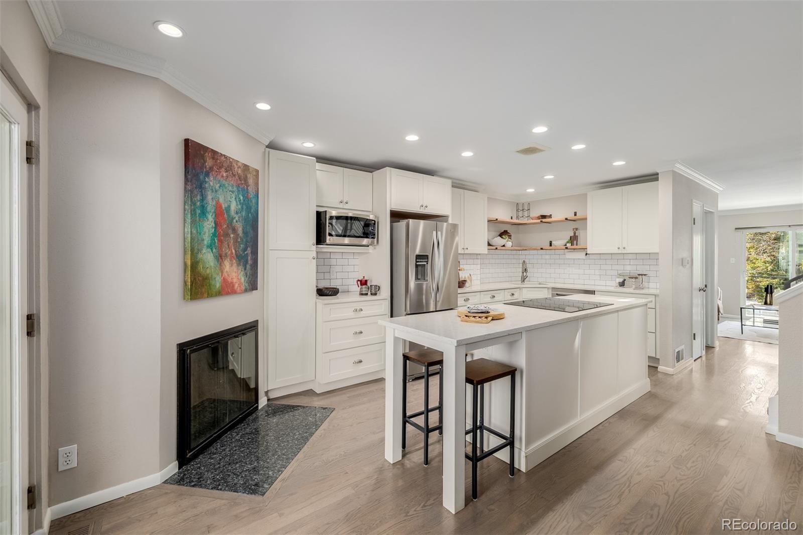 12 Jackson Street Denver, CO 80206 - Photo 3 of 48 a kitchen with a sink stainless steel appliances and white cabinets
