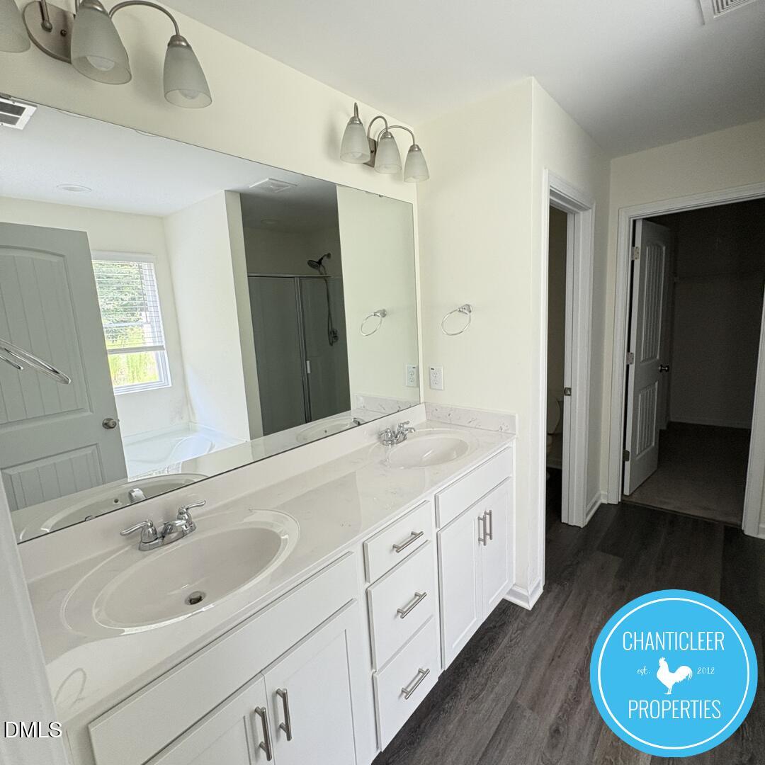 3318 Slippery Elm Drive Raleigh, NC 27610 - Photo 15 of 25 a bathroom with a double vanity sink and a mirror