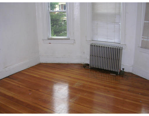 81 Montebello Road Boston, MA 02130 - Photo 3 of 9 an empty room with wooden floor and windows