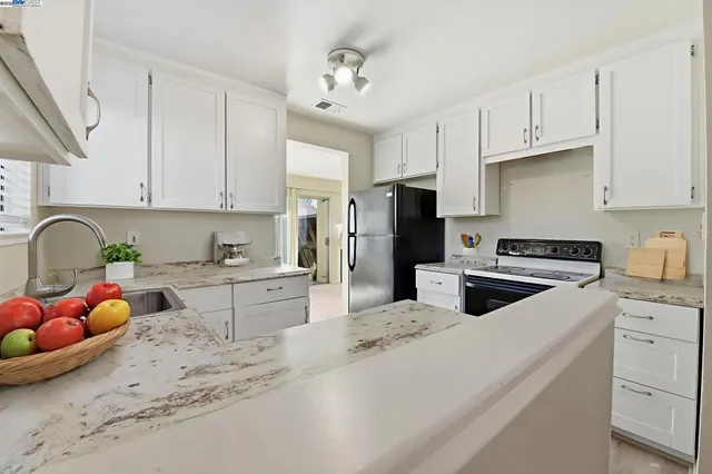 a kitchen with stainless steel appliances granite countertop a sink refrigerator and cabinets