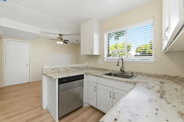 a kitchen with granite countertop cabinets stainless steel appliances a sink and a window