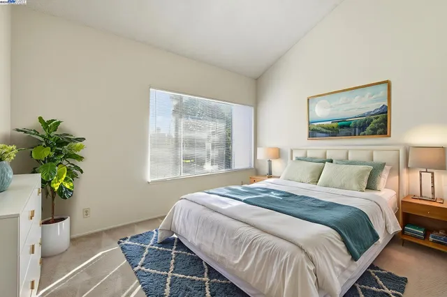 a bedroom with a bed potted plant and a window