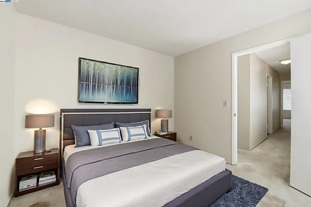 a bedroom with a bed and a painting on the wall