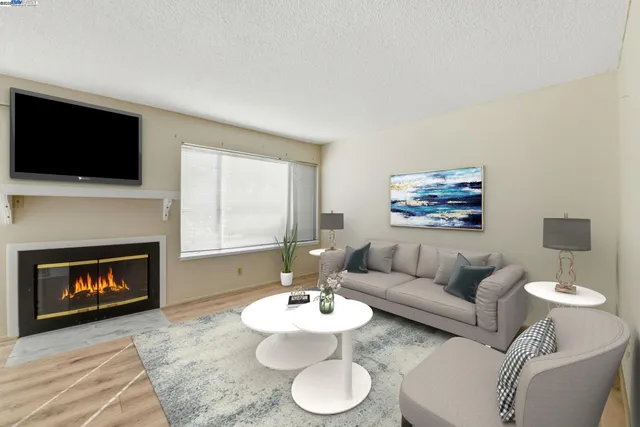 a living room with furniture a flat screen tv and a fireplace