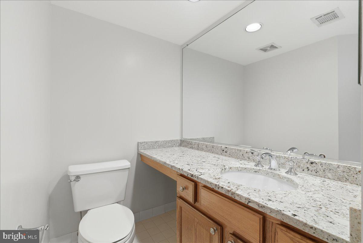 1304 F Garden Wall Circle Reston, VA 20194 - Photo 10 of 23 a bathroom with a granite countertop sink and a toilet