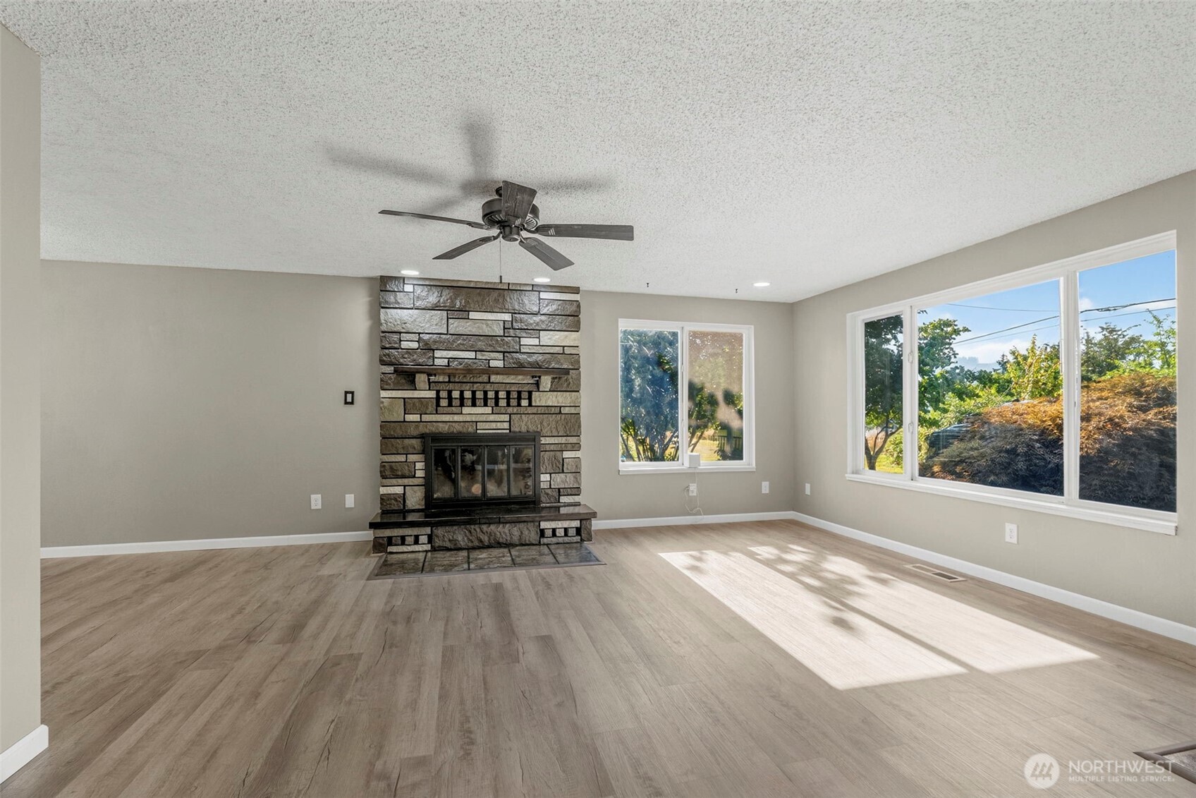 202 Waters Road Castle Rock, WA 98611 - Photo 6 of 38 a view of a livingroom with furniture wooden floor a ceiling fan and windows