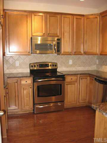 4709 Kings Garden Road Raleigh, NC 27612 - Photo 5 of 10 Stainless Steel Appliances, Tile Backsplash, Baltic Brown Granite Countertops, Coco Glace Flat Panel Maple Cabinets. Beautiful Kitchen!!