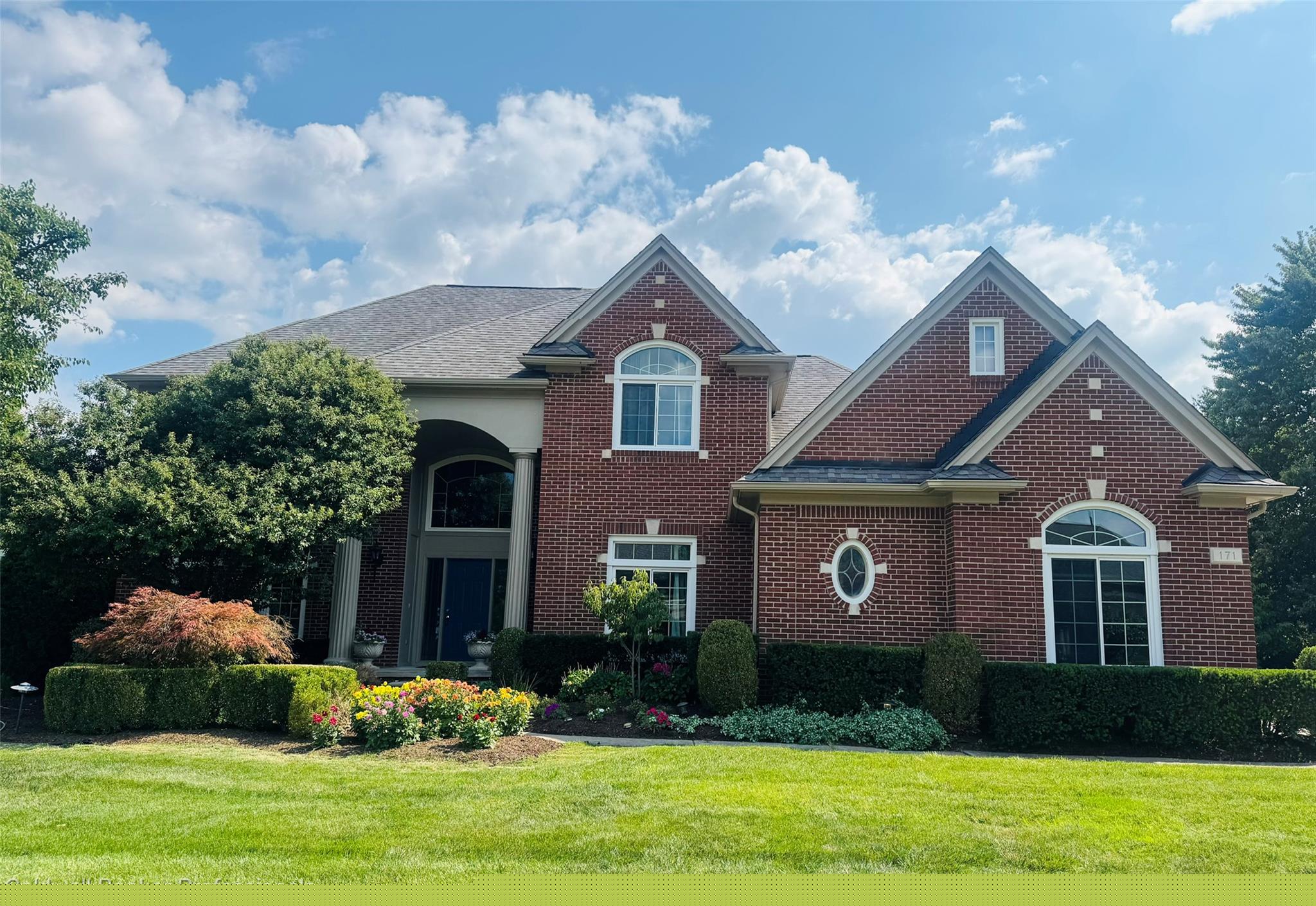 Brick facade residence with multiple gables and a covered portico entry