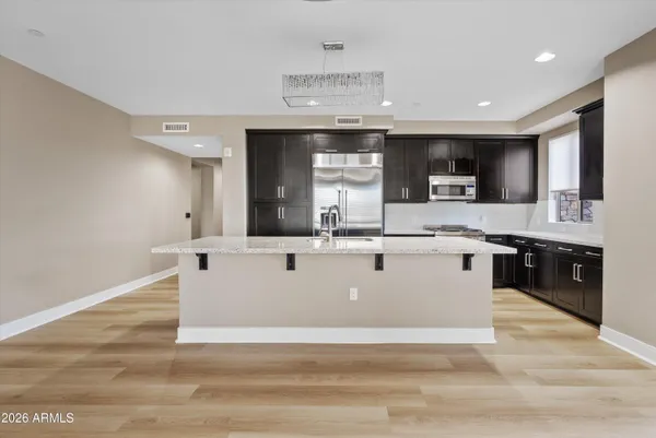 a view of kitchen with stainless steel appliances granite countertop a stove top oven a sink a counter space and cabinets