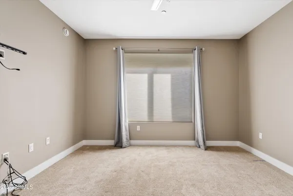 a bedroom with a bed and a flat tv screen on dresser