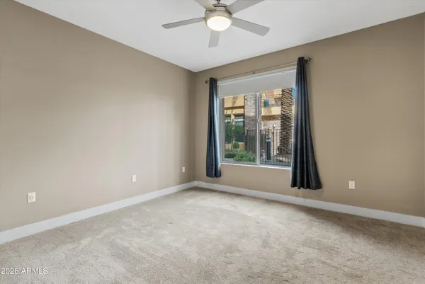 a bedroom with a bed a chair and a large window
